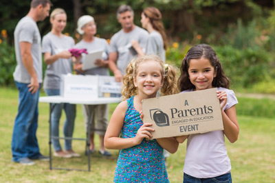 Children holding a Parents Engaged in Education events sign